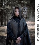 Small photo of Art photo of a warlike youth in a woolen coat with a large owl on his shoulder