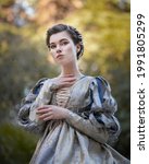 Small photo of Aristocratic woman in a medieval dress in a tropical garden