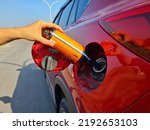 a driver fills a diesel additive into a car's diesel fuel tank to increase the cetane number and lower the sulfur content of biodiesel