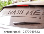 dirty car rear widescreen covered with dust with wording WASH ME , car wash and car care concept