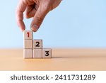 Small photo of Wooden Cube blocks with number first, second and third with copy space. Task priority and management concept. Activity order of priority. Set work priority, arrange to do list.