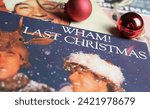Small photo of Viersen, Germany - January 9. 2024: Closeup of band Wham vinyl record single cover Last christmas from 1984 (focus on center of lower white lettering)