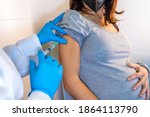 Small photo of Female doctor giving the coronavirus vaccine to a young pregnant woman. Antibodies, immunize population. side effects, risk people, antibodies, new normal, covid-19. Vertical photo