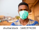 Small photo of young handsome african man wore face mask preventing, prevent, prevented himself from the outbreak in his society.