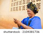 Small photo of beautiful african woman feeling excited as operating her cellphone