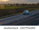 White delivery van on the highway. White modern delivery small shipment cargo courier van moving fast on motorway road to city urban suburb. The world's best transport of goods.