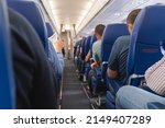 Passage in the plane.Economy class interior, aircraft cabin. Passengers sit in their seats.Family enjoying trip in aircraft. Transportation safety. 