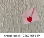 Envelope, seal with heart. True love. Message of the day. White wall, background.