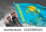 Small photo of Protests in Kazakhstan. The raised fists of the protesters and the state flags of Kazakhstan in the clouds of white smoke. Fight for human rights. A clenched male fist - a symbol of resistance
