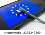 Small photo of European Union flag and USB Type c charger The only USB type C charger approved in the plenary session of the European Parliament.