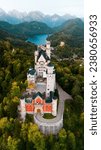 Small photo of Aerial drone view Neuschwanstein castle on Alps background in vicinity of Munich, Bavaria, Germany, Europe. Autumn landscape with castle and lake in mountains covered with spruce forest
