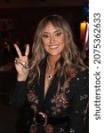 Small photo of Nashville, Tennessee - November 10, 2021: country singer Lainey Wilson flashing a peace sign while greeting fans on the street