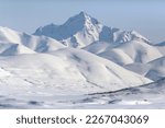 Winter mountain landscape. View of the snow-capped mountains. Majestic northern nature. Traveling and hiking in remote wilderness areas in the Arctic. Meingypilgyn Range, Chukotka, Far North of Russia