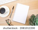 open notepad, cup of coffee, pen ,moose, keyboard on wooden background spiral notebook on table Business, planning, education, morning life working from home concept Top view Flat lay Mock up
