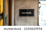 Small photo of Las Vegas, NV, USA 1-8-2022: Entrance foyer of WeWork Town Square, one of its two locations in the city. Metal placard with business name mounted on beige stucco wall. City in bokeh in the background.