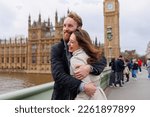 Happy couple of young travelers embrace against the background of London's Big Ben