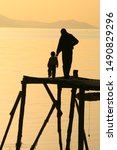 Small photo of man and boy silhouetted on a pier on Lake Iznik