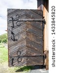 Small photo of Gate of the Kvikne Stave Church, a cruciform church dating from 1764 in the municipality of Nord-Fron in Oppland county, Norway. Thick wooden door has decorative forged details.