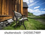 Small photo of Vintage wooden bench next to the Kvikne Stave Church, a cruciform church dating from 1764 in the municipality of Nord-Fron in Oppland county, Norway. Wooden tarry wall with forged details.