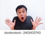 Asian man feels shock and surprise with overly face expression.