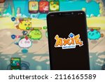Small photo of Cali, Colombia - January 26 2022: "Axie Infinity" game logo on the smartphone screen. It's NFT-based online game using play to earn business concept.