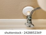 Small photo of Residential home bathroom toilet water shut off valve. Replacing old leaking restroom wall supply line valve plumbing.