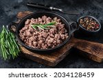 Fried mince beef meat in a pan for cooking pasta. Black background. Top view