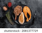 Grilled meat steaks - fish salmon, beef veal and turkey fillet. Black background. Top view