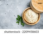 Pyanse steamed bun in a Bamboo steamer, korean street food. Gray background. Top view. Copy space.
