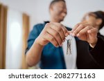 Small photo of Close-up of hands holding keys to an apartment, married couple buying, renting a new apartment, the beginning of their journey together, real estate industry, investment