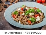 Whole grain pasta with cheese, tomato and basil