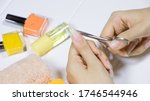 Small photo of Manicure. Cut your fingernails with small nail scissors. Trim your nails. Young woman taking care of her nails. Hygiene, clipping, cutter, self, skincare, procedure, routine, treatment.