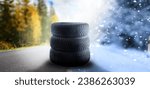 Small photo of Swap winter tires for summer tires - time for summer tires. Winter tires on a asphalt road. Four wheel off. Change a summer tyre. Forest road with trees in blurred background. Change for new tire.