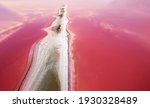 Small photo of The background of the pink water of the pink lake and the elongated protrusion of the island formed of salt and sand