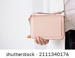 Close-up of a young girl holding a stylish powder-colored bag in her hand. The concept of women's fashion.