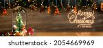 Small photo of Merry Christmas and Happy new year xmas tree and santa claus in glass dome decor with bauble reindeer,pine cone tinsel at wood background
