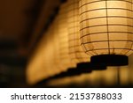 Small photo of close up a row of traditional Japanese paper lanterns in diminishing perspective at night