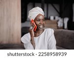 Nice African girl in turban talks by phone home smiles wide happy to hear friend, missing them after relocation. Successful African American businesswoman in traditional clothes speaks by smartphone.