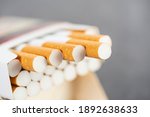 Small photo of Open pack of cigarettes with several stretched cigarettes close-up.