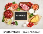 Small photo of Assortment of high vitamin B sources on white background: milk, liver, olive oil, tomatoes, prawns, peanuts, beef, spinach, salmon, keshew, cheese, eggs, haricot. Top view.