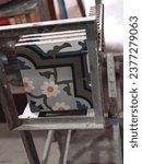 Small photo of Handmade stylish designed geometric ceramic tiles with colorful ornaments placed on metal framed construction of stencil in workshop