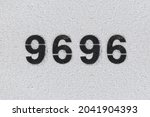 Small photo of Black Number 9696 on the white wall. Spray paint. Number nine thousand six hundred ninety-six.