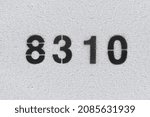 Small photo of Black Number 8310 on the white wall. Spray paint. Number eight thousand three hundred and ten.