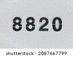 Small photo of Black Number 8820 on the white wall. Spray paint. Number eight thousand eight hundred and twenty.