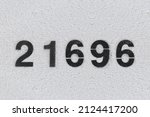 Small photo of Black Number 21696 on the white wall. Spray paint.two hundred and one thousand six hundred and ninety-sixtwo hundred and one thousand six hundred and ninety-six