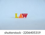 Small photo of Word 'Law' on white background. The system of rules which a particular country or community recognizes as regulating the actions of its members and which it may enforce by the imposition of penalties.