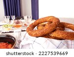 Small photo of Turkish breakfast concept with bagel called simit in Turkish. Beautiful table presentation. Ready for guests. Delicious repast, brunch, classic morning feast. Empty water glasses. Copy space.