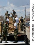 Small photo of BILOXI, UNITED STATES - Sep 06, 2005: Air Force Personnel unload boxes of bottled water for Hurricane Katrina victims.