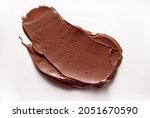 A closeup view of delicious chocolate paste smeared on white background in studio