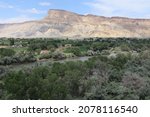A scenic view of a valley across the Colorado River to Mt  Garfield in Colorado, USA